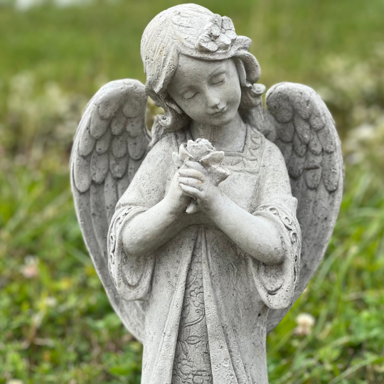Angel standing holding flowers statue