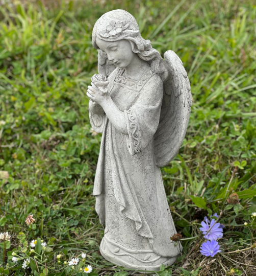Angel standing holding flowers statue