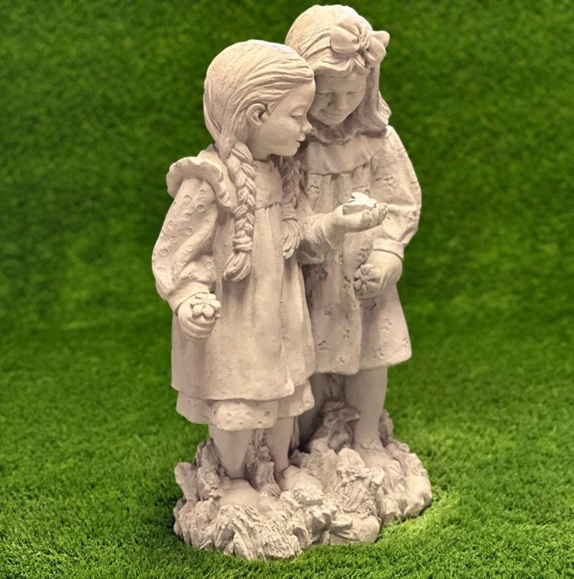 Two girls playing with butterfly statue