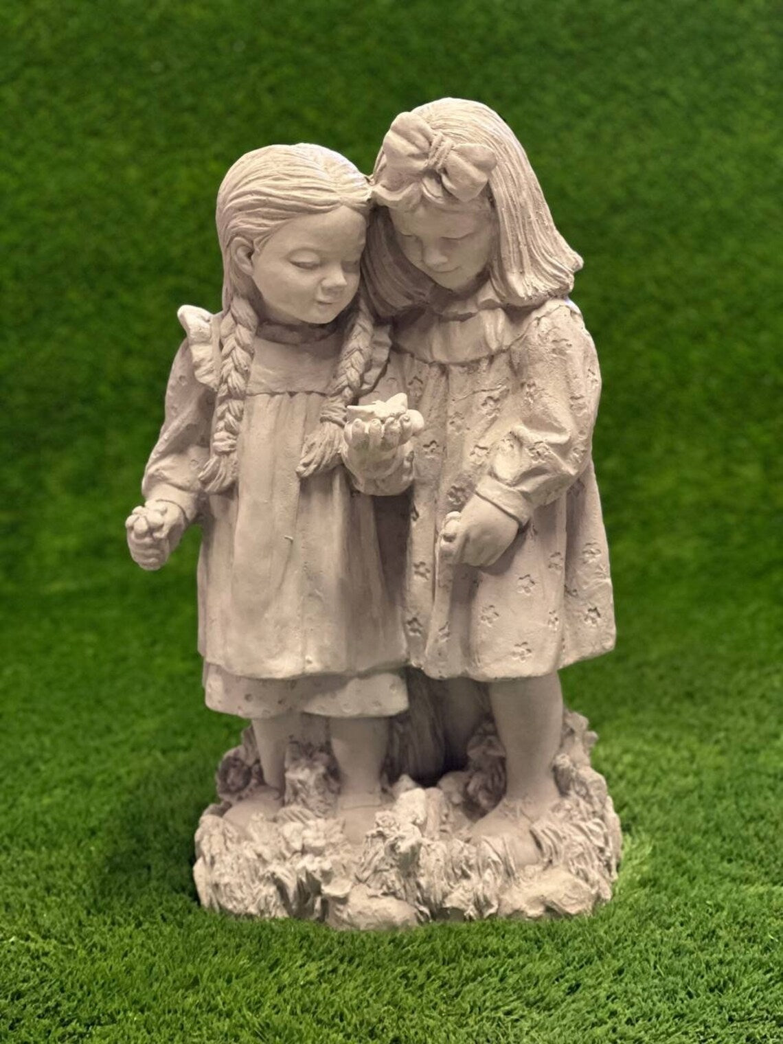 Two girls playing with butterfly statue