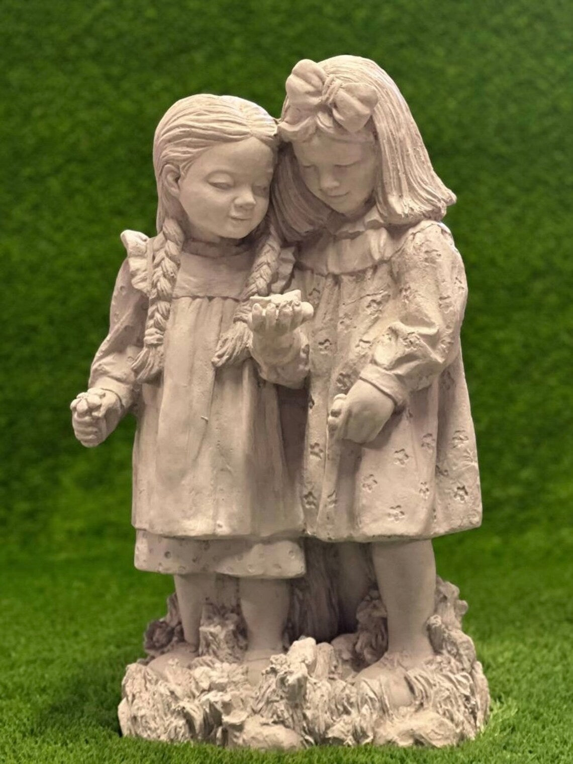 Two girls playing with butterfly statue