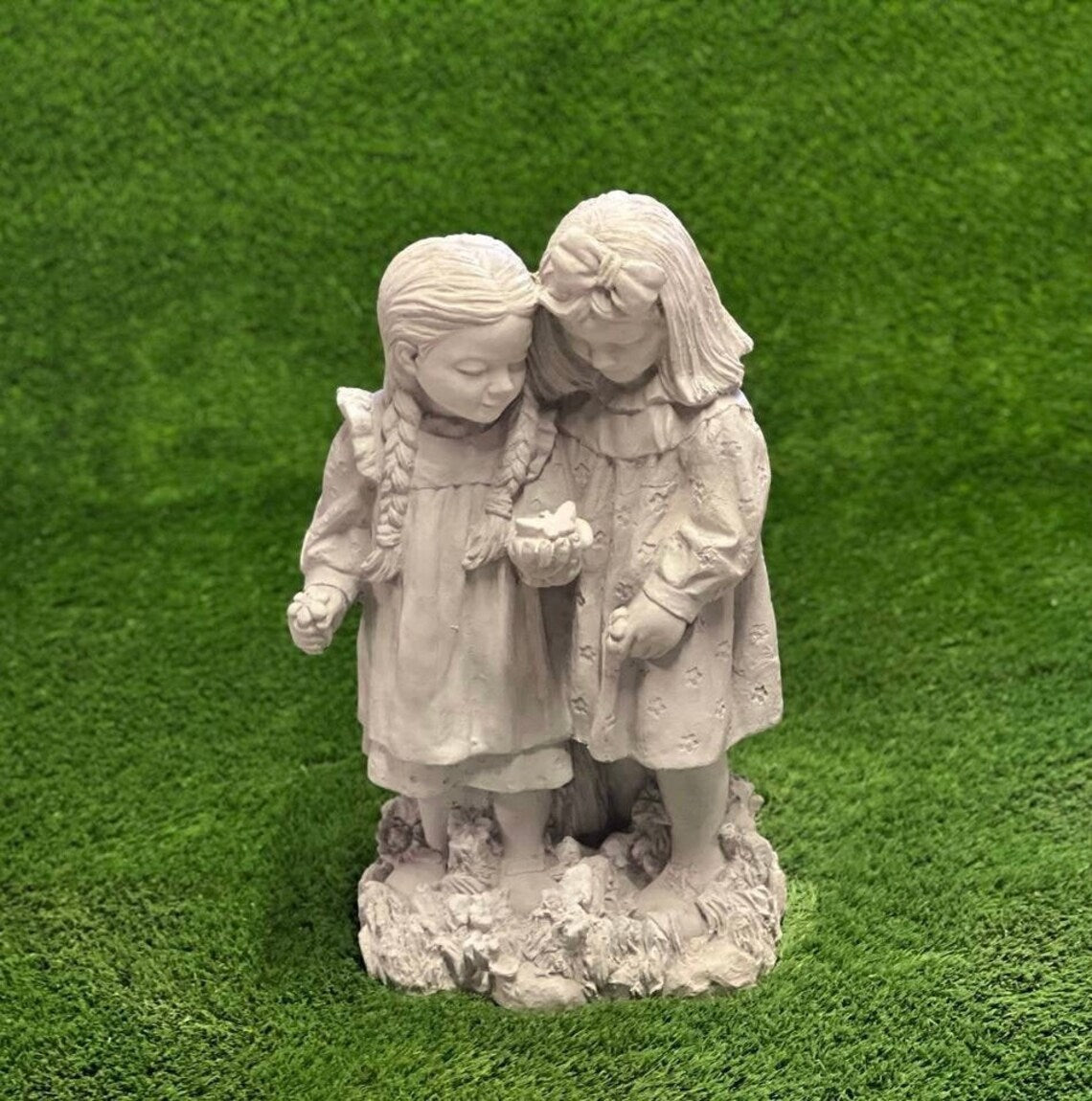 Two girls playing with butterfly statue