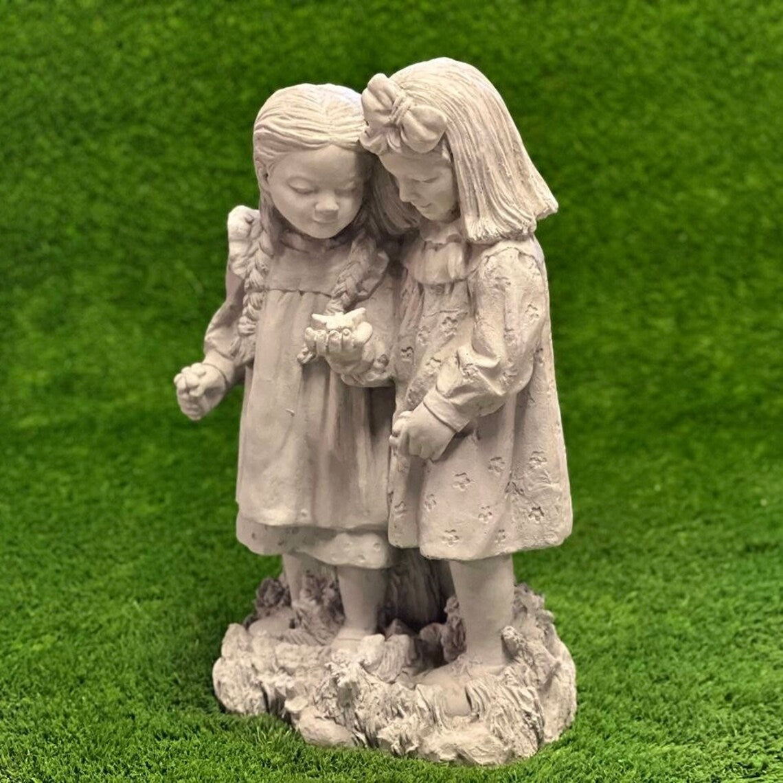 Two girls playing with butterfly statue
