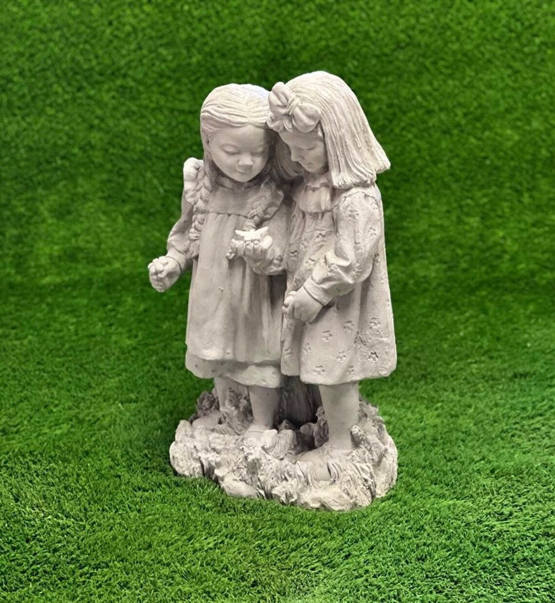 Two girls playing with butterfly statue