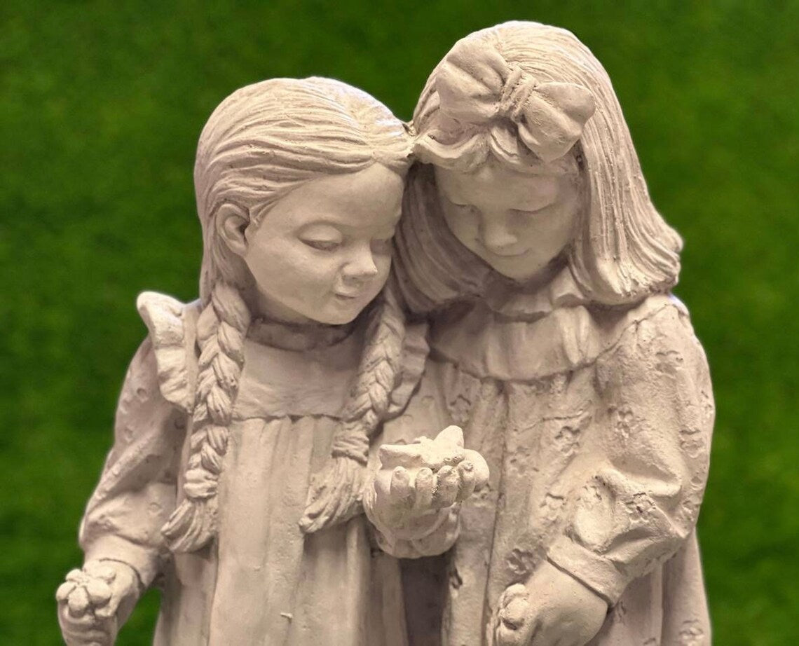 Two girls playing with butterfly statue