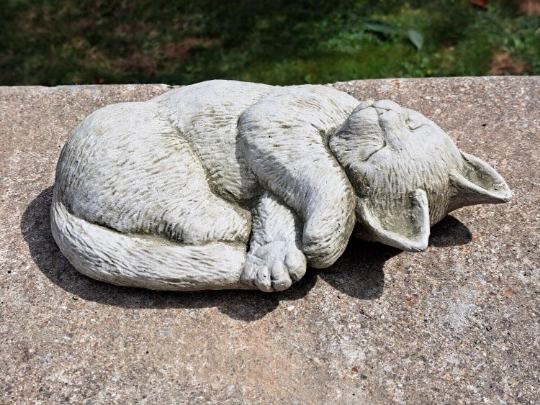 Outdoor curled up cat figurine