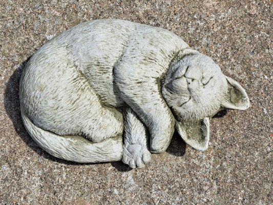 Outdoor curled up cat figurine