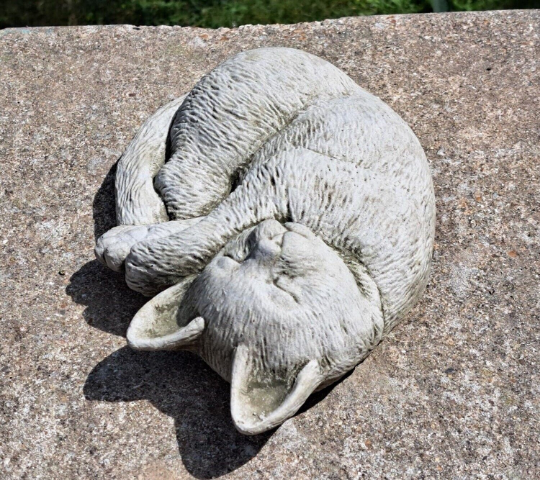 Outdoor curled up cat figurine