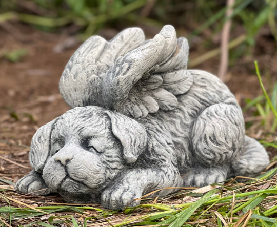 Concrete sleeping dog with wings statue