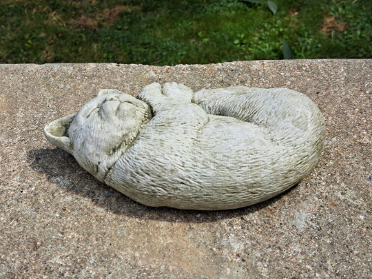 Outdoor curled up cat figurine