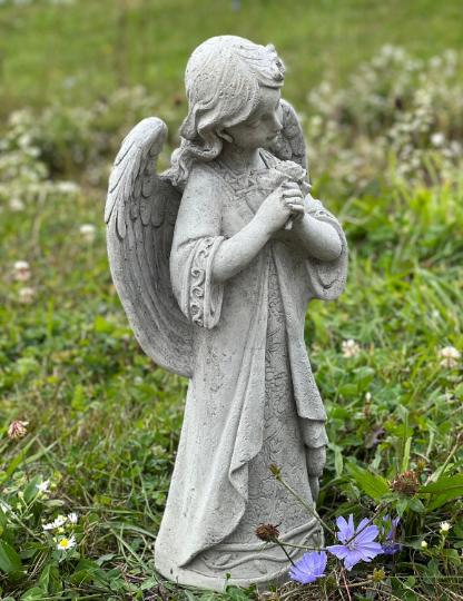 Angel standing holding flowers statue