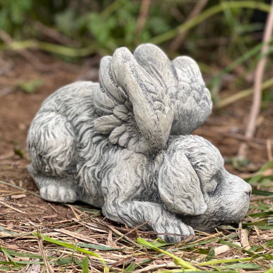 Concrete sleeping dog with wings statue