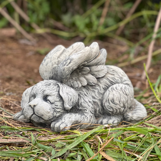 Concrete sleeping dog with wings statue