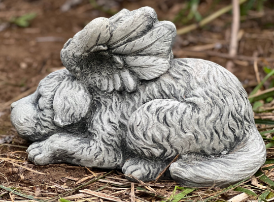 Concrete sleeping dog with wings statue