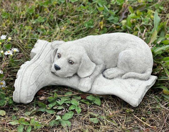 Concrete dog laying on boot statue