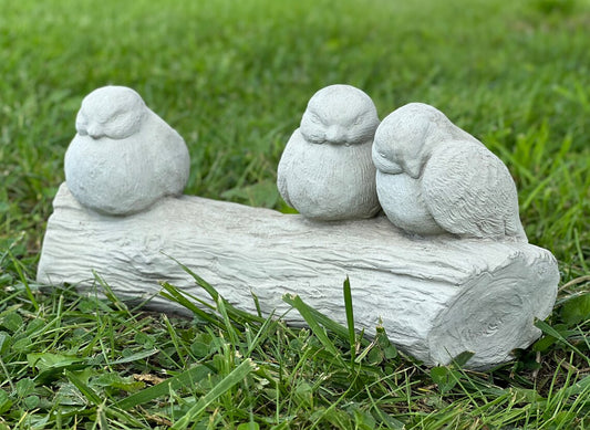 Three birds sitting on stump statue