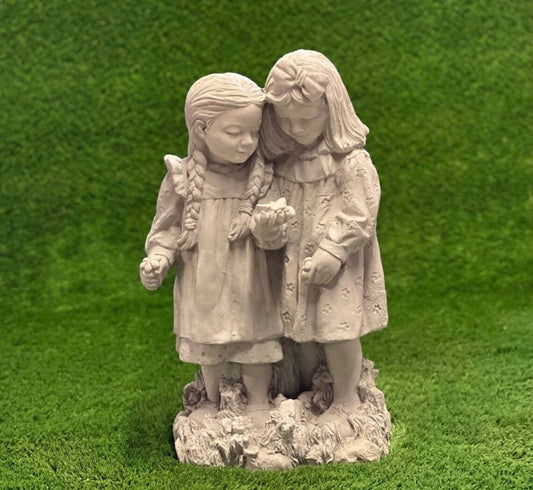 Two girls playing with butterfly statue