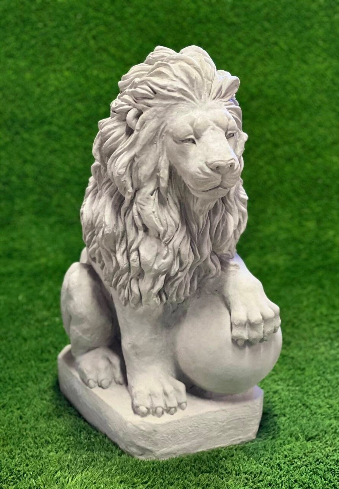 Lion with paw on ball statue