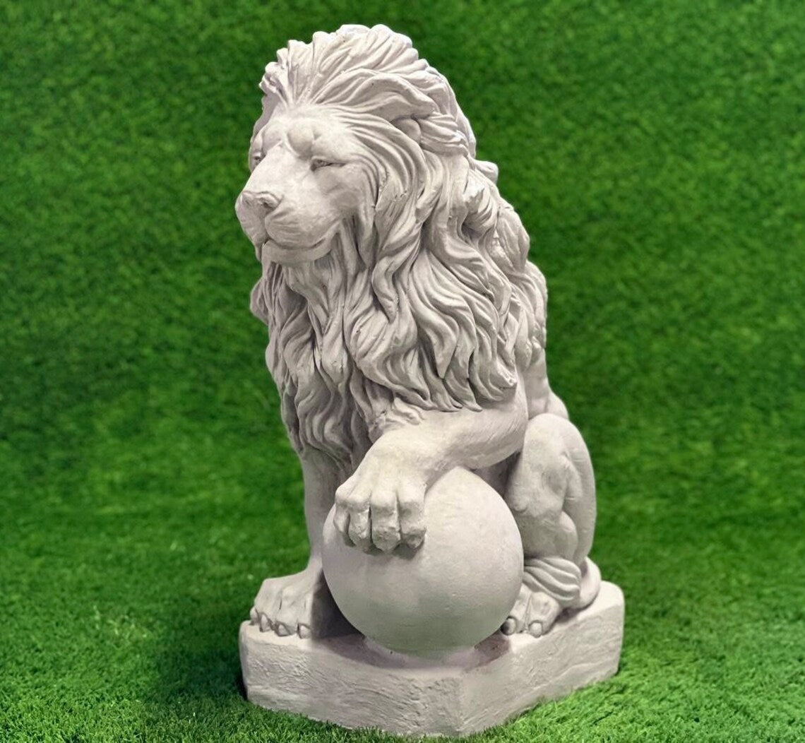 Lion with paw on ball statue